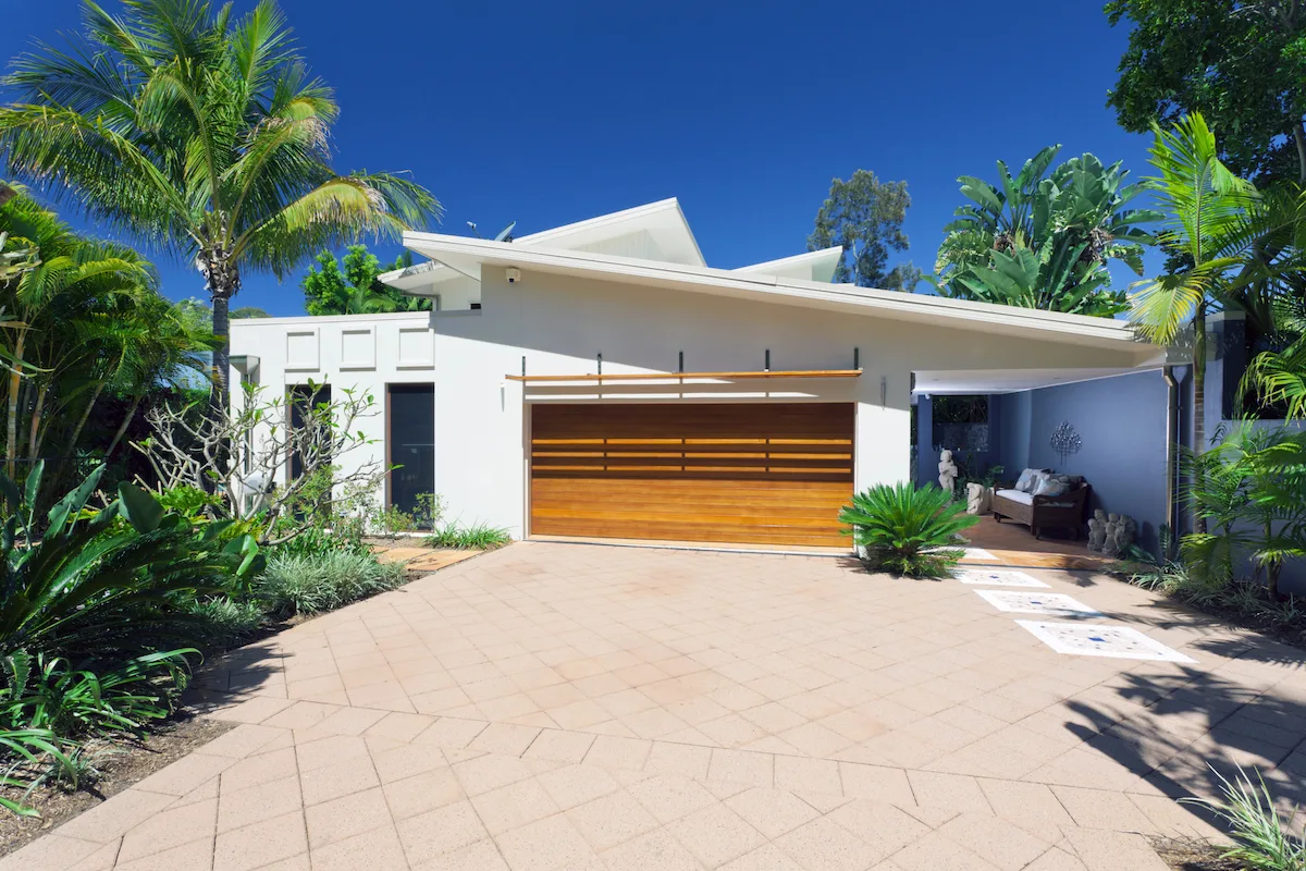 Modern home driveway framed by palms and drought-tolerant garden planting