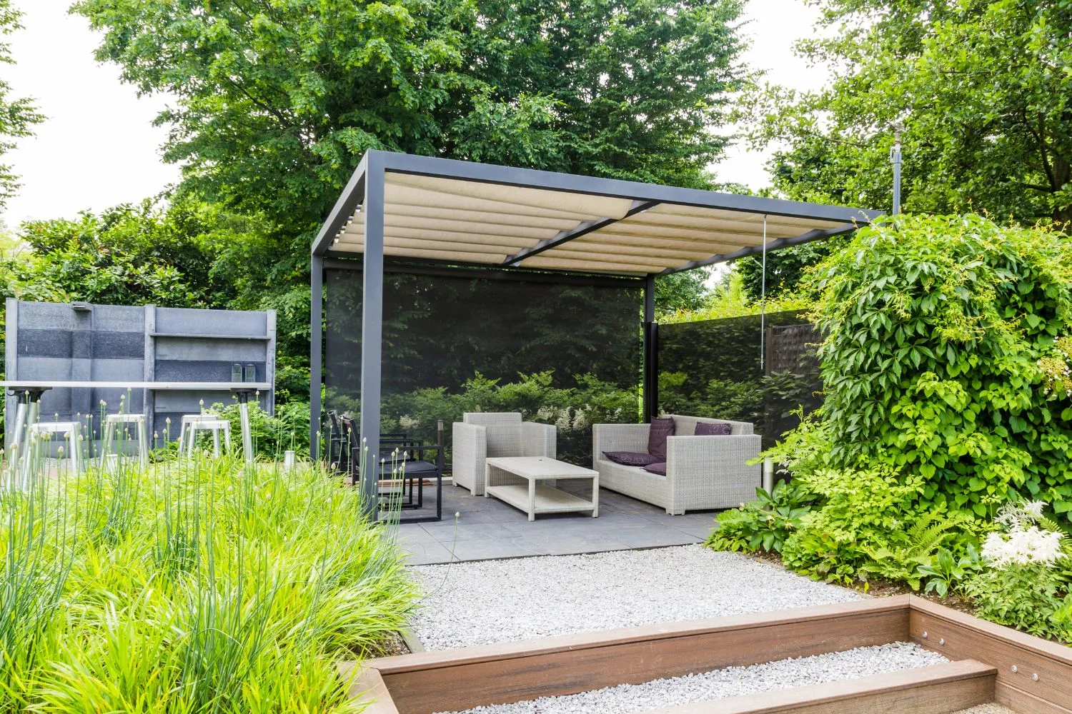 Pergola-covered outdoor seating area with gravel paving and timber steps